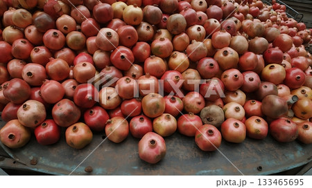 A large pile of pomegranates are stacked together ready for market sale 133465695