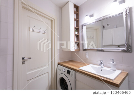 A modern laundry room designed with stylish fixtures and an appealing interior design aesthetic 133466460