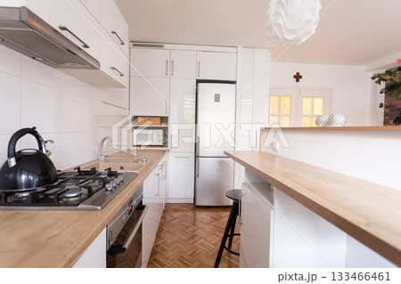A modern kitchen that features a sleek design combined with a warm and cozy atmosphere 133466461