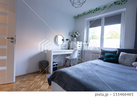 A Modern Bright Bedroom with a Desk and Natural Light creates a serene atmosphere for relaxation 133466465