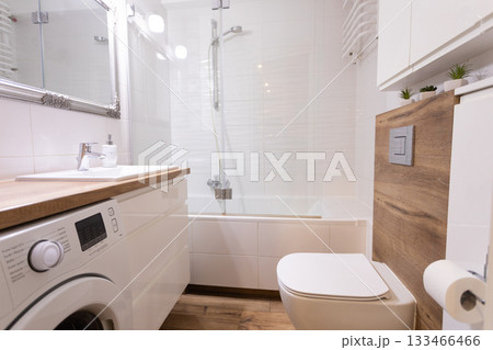 A Modern Bathroom featuring a Bathtub and Washer designed with a Clean and Stylish Aesthetic A Modern Bathroom featuring a Bathtub and Washer designed with a Clean and Stylish Aesthetic 133466466