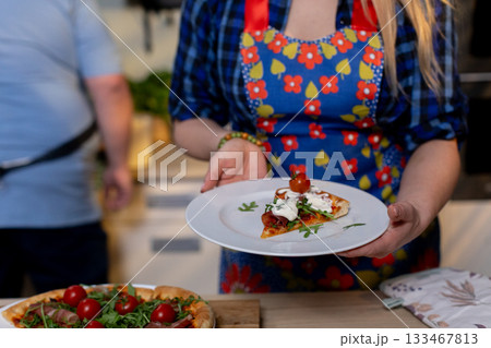 Enjoy a Delicious Homemade Pizza Served on a Beautiful Plate for Everyone to Enjoy 133467813