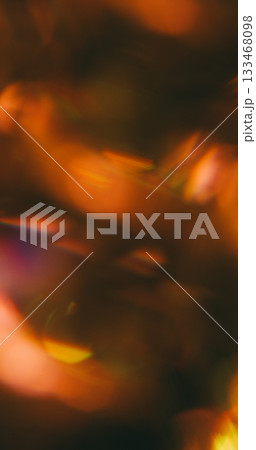 Defocused crystal flash. Flare blend. Bokeh night light mix color. Yellow orange brown prism shimmering texture abstract black background. 133468098