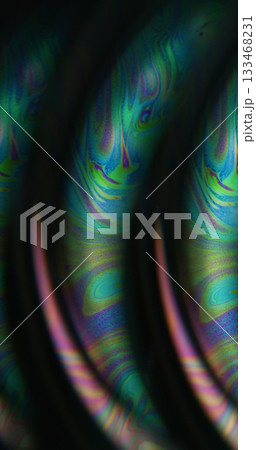 Defocused oil liquid. Psychedelic paint. Green blue neon color wet bubble acrylic curve texture floating on abstract creative dark black background. 133468231