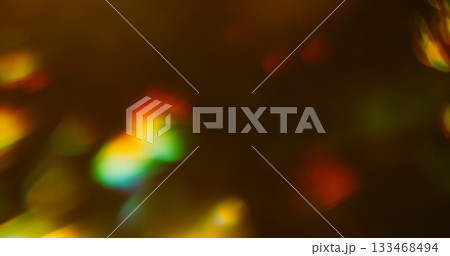 Blur colorful leak. Prism bokeh lens. Vivid beam flare in dark black background. Yellow green red reflection abstract art luminosity. 133468494