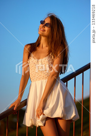 Slavic Woman in White Dress on Railing 133469218