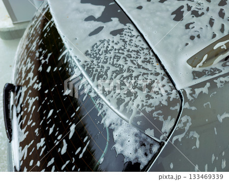 Foamy bubbles and shining surfaces during a weekend car wash on a sunny afternoon, capturing the joy of a clean ride 133469339