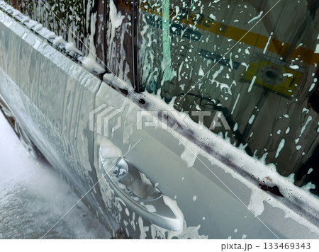 Foamy car wash experience on a sunny afternoon in the neighborhood, creating a refreshing atmosphere and clean vehicles Foamy car wash experience on a sunny afternoon in the neighborhood, creating a refreshing atmosphere and clean vehicles 133469343
