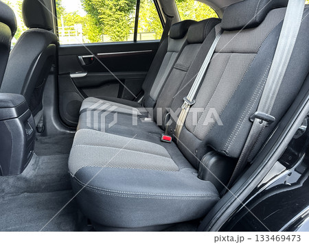 Interior of a spacious vehicle showcasing comfortable back seats and ample legroom in bright daylight, emphasizing quality and design for a relaxed ride experience 133469473
