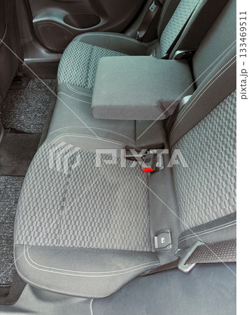 Comfortable backseat area of a modern car with clean upholstery and a foldable armrest during a sunny day Comfortable backseat area of a modern car with clean upholstery and a foldable armrest during a sunny day 133469511