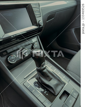 Modern car interior with sleek gear shift and advanced audio controls in a stylish, minimalist design Modern car interior with sleek gear shift and advanced audio controls in a stylish, minimalist design 133469526