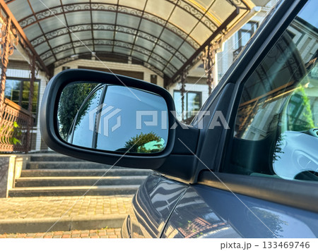 Reflecting elegance on a sunny day at a stunning entrance with intricate architecture and a stylish vehicle parked nearby 133469746