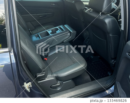 Spacious interior of a modern vehicle showcasing rear seating area and console design on a sunny day 133469826