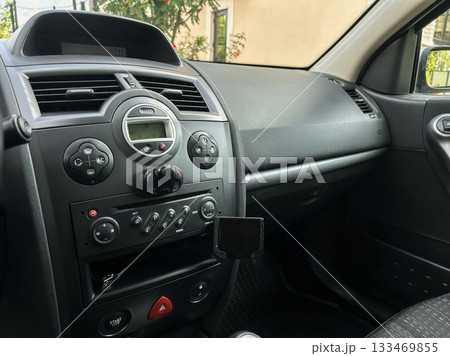 Interior of a modern car showcasing dashboard controls and center console on a sunny day in an urban setting Interior of a modern car showcasing dashboard controls and center console on a sunny day in an urban setting 133469855