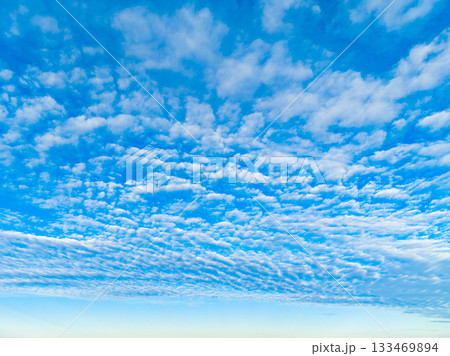 Vast blue sky adorned with fluffy white clouds during a serene afternoon, inviting moments of reflection and joy while nature unfolds 133469894