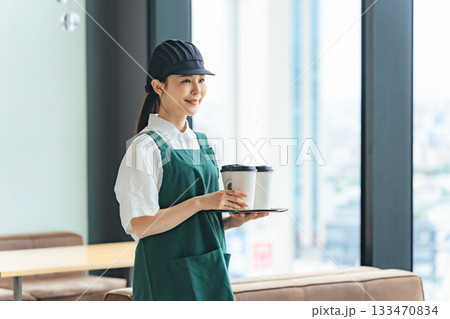 笑顔で紙コップを持つ飲食店店員 笑顔で紙コップを持つ飲食店店員 133470834