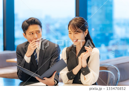 飲食店でメニューを見て喜ぶ女性と悩む男性のカップル 飲食店でメニューを見て喜ぶ女性と悩む男性のカップル 133470852