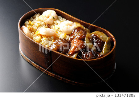 海老炒飯黒酢酢豚弁当を黒背景で撮影 133471808