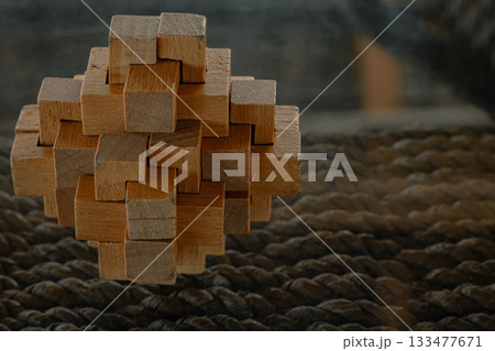 Wooden puzzle pieces forming an abstract interlocking design 133477671