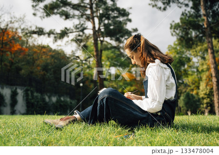 Girl Drawing in Summer Park. Relax lifestyle portrait  133478004
