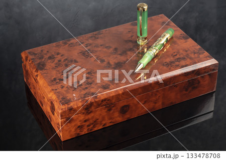 A branded fountain pen next to a box. Gift set. Selective focus. Office interior 133478708