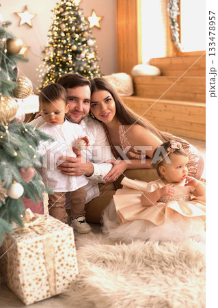 Family celebration with children during festive season at cozy indoor setting with decorative tree and gifts Family celebration with children during festive season at cozy indoor setting with decorative tree and gifts 133478957