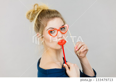 woman holds carnival accessories on stick 133479713