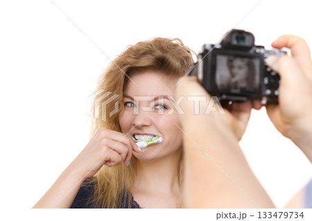 Taking picture of woman brushing teeth Taking picture of woman brushing teeth 133479734