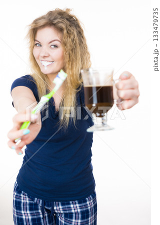 Happy woman holding toothbrush and coffee Happy woman holding toothbrush and coffee 133479735
