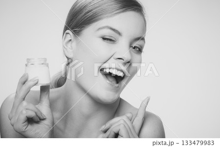 woman applying cream on her skin face. 133479983