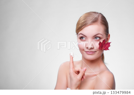 Skin care. Face of young woman girl with red maple leaf. 133479984