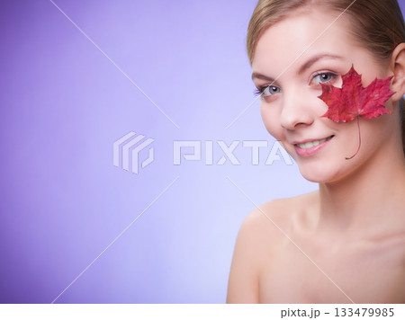Skin care. Portrait of young woman girl with red maple leaf. 133479985