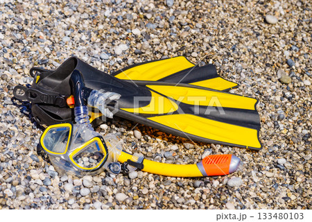 Flippers and snorkeling tube on sea shore Flippers and snorkeling tube on sea shore 133480103