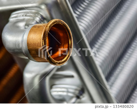 Close-up view of a metallic automotive part showcasing intricate details and vibrant copper finish in a workshop setting Close-up view of a metallic automotive part showcasing intricate details and vibrant copper finish in a workshop setting 133480820