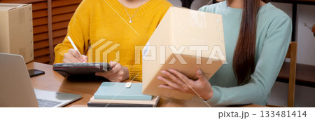 Two asian woman working while planning online business and checking order with writing on tablet. Two asian woman working while planning online business and checking order with writing on tablet. 133481414