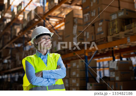 Senior woman manager or supervisor standing in a warehouse, arms crossed. Senior woman manager or supervisor standing in a warehouse, arms crossed. 133482186