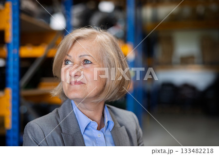 Senior woman warehouse manager or supervisor , arms crossed. 133482218