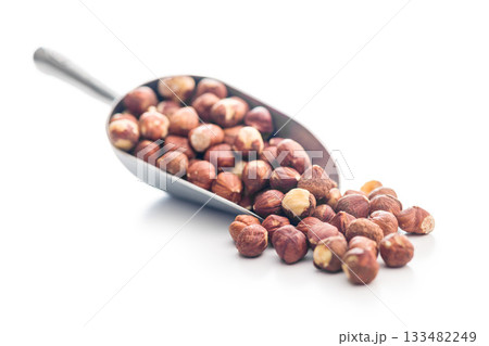 Peeled hazelnut kernels in scoop isolated on white background. 133482249