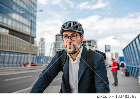 City commuter riding bike to office, wearing backpack and helmet. 133482365