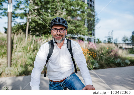 City commuter riding bike to office, wearing backpack and helmet. City commuter riding bike to office, wearing backpack and helmet. 133482369