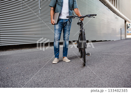 Man riding bike to work in city with helmet and backpack Man riding bike to work in city with helmet and backpack 133482385