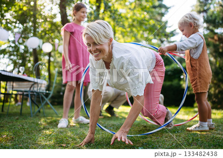 Family enjoying outdoor summer gathering with playful activities. Family enjoying outdoor summer gathering with playful activities. 133482438