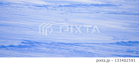 風で風紋が見える日没間近の雪原の寒そうな風景 133482591