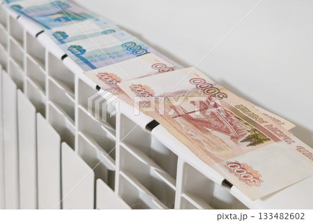 Russian banknotes on heating radiator battery. 133482602