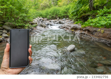 長野県南牧村の渓流でスマートフォンを持つ手、通信・デジタルデトックスのイメージ 長野県南牧村の渓流でスマートフォンを持つ手、通信・デジタルデトックスのイメージ 133482756