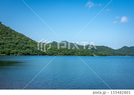 群馬県大沼の青空と湖、夏の雄大な水面と山並みの風景 133482801