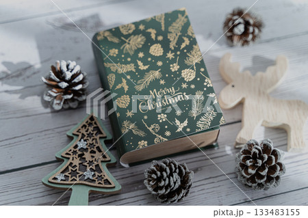 緑色のブック型ボックスと松ぼっくりのクリスマスディスプレイ 133483155