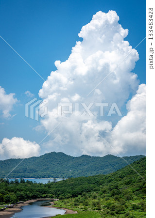 群馬県覚満淵と上空に湧き立つ積乱雲、夏の雄大な空と湿原 群馬県覚満淵と上空に湧き立つ積乱雲、夏の雄大な空と湿原 133483428