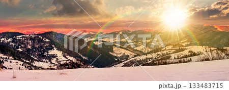 panorama of mountain ridge in winter at sunset. beautiful landscape with forested hills in snow. clouds on sky and mountain tops lit by evening light. leadership corporate wallpaper under the rainbow panorama of mountain ridge in winter at sunset. beautiful landscape with forested hills in snow. clouds on sky and mountain tops lit by evening light. leadership corporate wallpaper under the rainbow 133483715