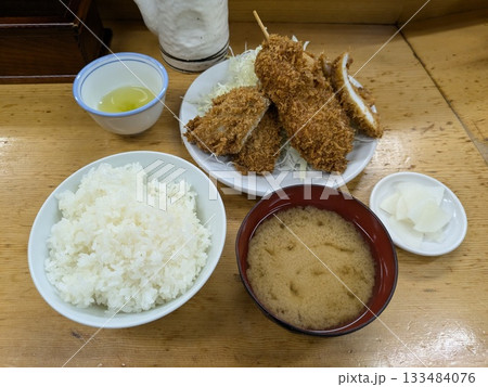 豚カツが乗ったご飯とルーが入ったカレーポットとトッピングのある食卓 豚カツが乗ったご飯とルーが入ったカレーポットとトッピングのある食卓 133484076